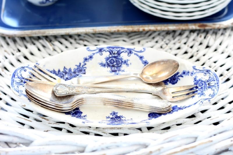 vintage spoons and blue and white ironstone dish for an easy Spring touch on a white wicker tray.