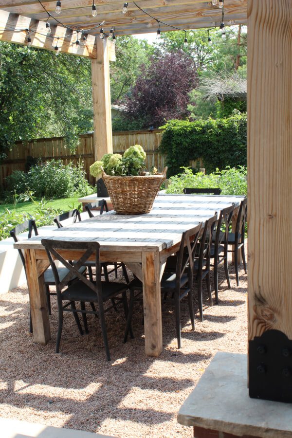 A view of our outdoor wooden dining table and black metal x back chairs.