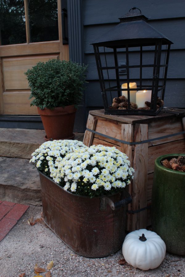 Fall on the steps of our house include mums, copper pots, pinecones, lanterns and candles.