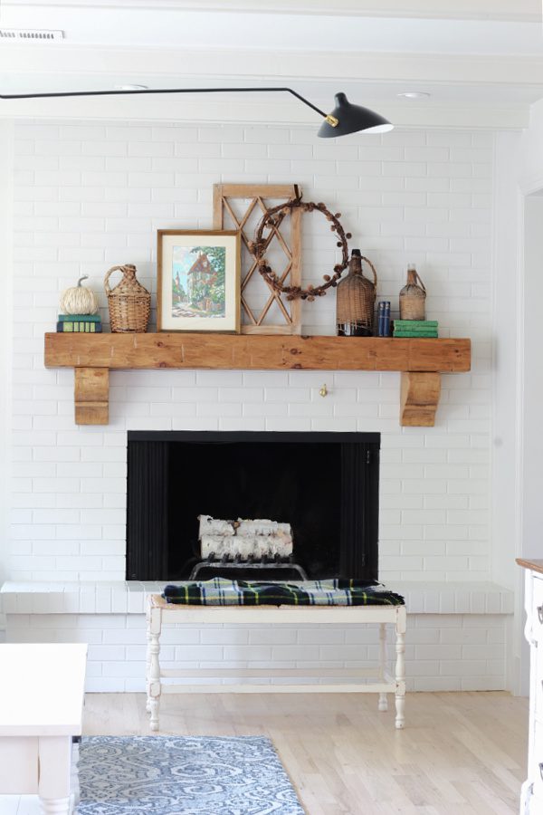 Fall mantel  with rattan, paint by number art, plaid and touches of blue and green.